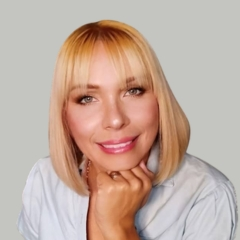 Foto perfil busto de logo Mariana Perez, rubia mirando la camara con posando su barbilla sobre su mano empuñada.